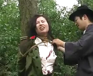 Asian army dame strapped to tree 1
